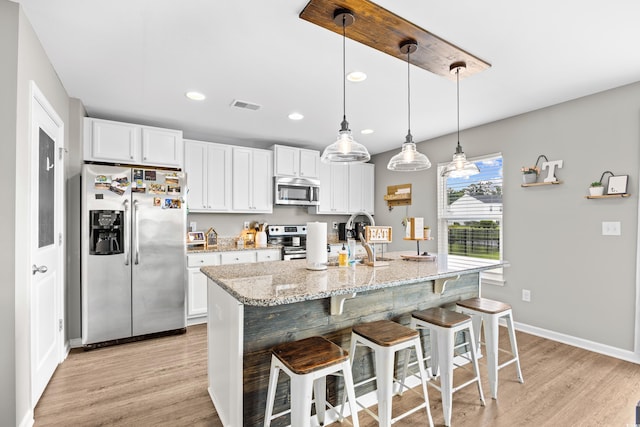 317 Truce St, Myrtle Beach, SC 29588 - kitchen featuring stainless steel appliances, light wood-type flooring, white cabinetry, a kitchen breakfast bar, and recessed lighting