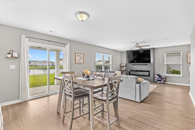 317 Truce St, Myrtle Beach, SC 29588 - dining space featuring light wood-style flooring, a fireplace, and a ceiling fan
