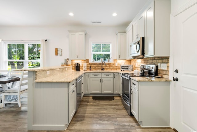 2588 Long Ave, Conway, SC 29526 - kitchen with appliances with stainless steel finishes, a peninsula, decorative backsplash, light stone counters, and recessed lighting