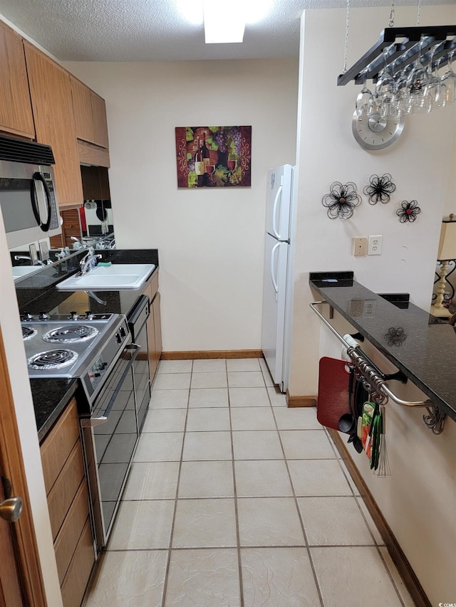 207 Double Eagle Dr Unit E-1, Surfside Beach, SC 29575 - kitchen featuring stainless steel appliances, light tile patterned floors, and a textured ceiling
