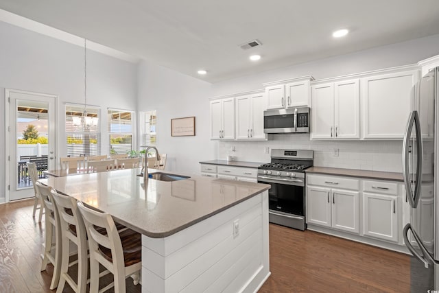405 Spring View Ct, Little River, SC 29566 - kitchen with appliances with stainless steel finishes, a chandelier, dark wood-type flooring, decorative backsplash, and white cabinetry