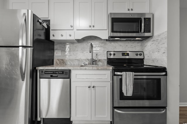920 N Waccamaw Dr Unit 2310, Murrells Inlet, SC 29576 - kitchen with stainless steel appliances, decorative backsplash, white cabinets, and light stone counters
