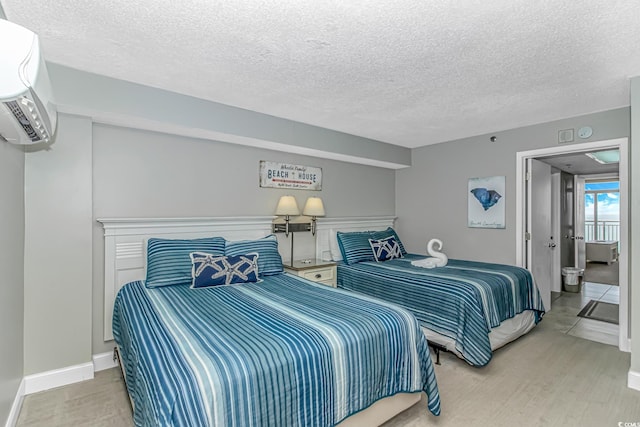 201 S Ocean Blvd Unit 616, Myrtle Beach, SC 29577 - bedroom featuring a textured ceiling, wood finished floors, and an AC wall unit