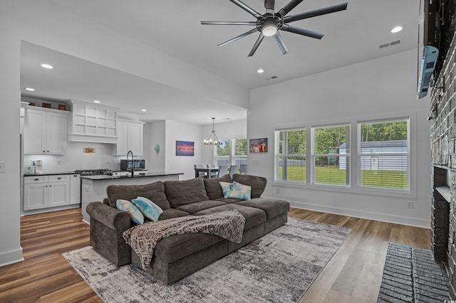 1253 Kenworth Cir, Conway, SC 29526 - living room with ceiling fan, a chandelier, dark wood-style floors, recessed lighting, and a fireplace