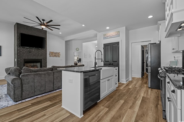 1253 Kenworth Cir, Conway, SC 29526 - kitchen with appliances with stainless steel finishes, open floor plan, white cabinetry, a kitchen island with sink, and wood finished floors