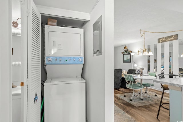 1101 2nd Ave N Unit 1501, Surfside Beach, SC 29575 - washroom featuring estacked washer and dryer, wood finished floors, and a chandelier