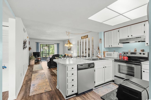 1101 2nd Ave N Unit 1501, Surfside Beach, SC 29575 - kitchen featuring appliances with stainless steel finishes, under cabinet range hood, a peninsula, open floor plan, and dark wood-type flooring
