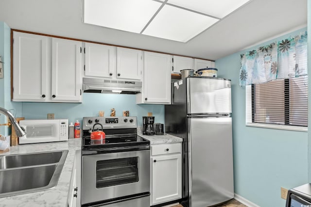 1101 2nd Ave N Unit 1501, Surfside Beach, SC 29575 - kitchen featuring stainless steel appliances, under cabinet range hood, white cabinets, and light stone countertops