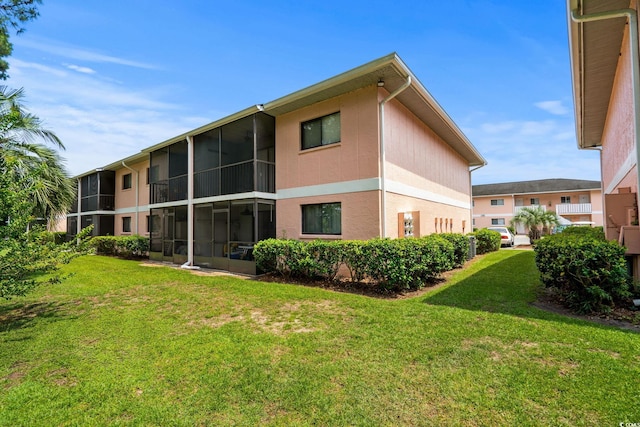 1101 2nd Ave N Unit 1501, Surfside Beach, SC 29575 - rear view of property with a sunroom, a lawn, and stucco siding