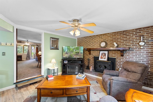1272 Park Hill Dr, Conway, SC 29526 - living area with a ceiling fan, wood finished floors, a wood stove, brick wall, and crown molding