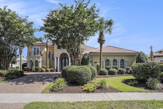 1503 Cadiz Dr, Myrtle Beach, SC 29579 - mediterranean / spanish-style house featuring a balcony, stucco siding, decorative driveway, and a tile roof