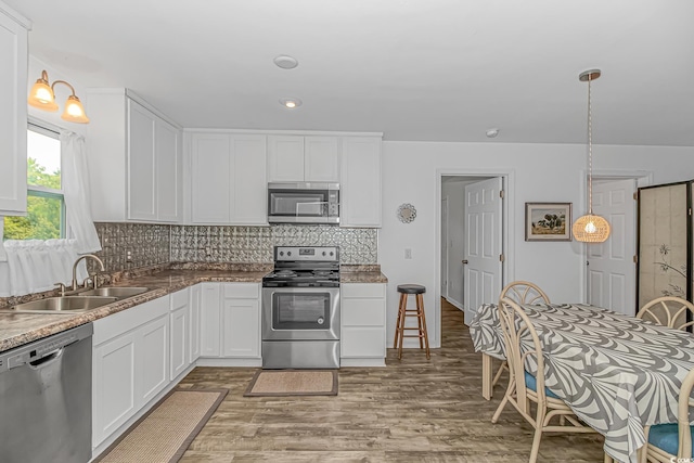 175 Cypress Ln, Little River, SC 29566 - kitchen with appliances with stainless steel finishes, light wood-style floors, decorative backsplash, white cabinets, and recessed lighting