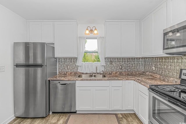 175 Cypress Ln, Little River, SC 29566 - kitchen with appliances with stainless steel finishes, white cabinets, light wood-style floors, and decorative backsplash