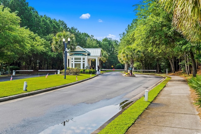 5008 Hayes Bay Ct, Murrells Inlet, SC 29576 - view of asphalt road with street lights, curbs, sidewalks, view of scattered trees, and a gated entry