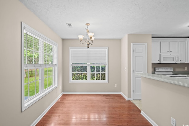 5008 Hayes Bay Ct, Murrells Inlet, SC 29576 - kitchen featuring white appliances, light wood-style floors, a chandelier, white cabinets, and decorative light fixtures