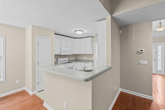 5008 Hayes Bay Ct, Murrells Inlet, SC 29576 - kitchen with white appliances, light wood-style flooring, white cabinetry, a peninsula, and a textured ceiling