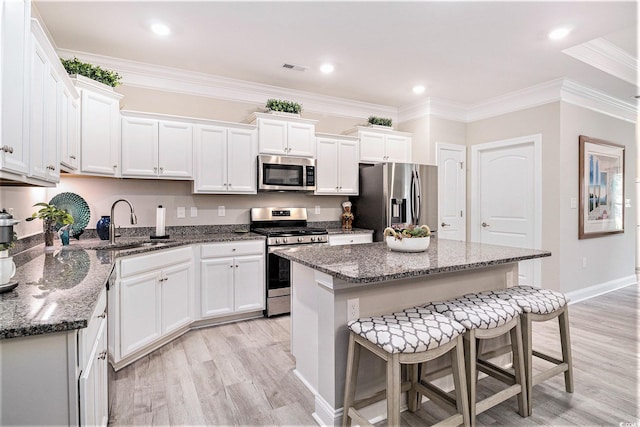 800 Monarch Dr Unit 49, Myrtle Beach, SC 29588 - kitchen with appliances with stainless steel finishes, a breakfast bar, light wood finished floors, a kitchen island, and white cabinets