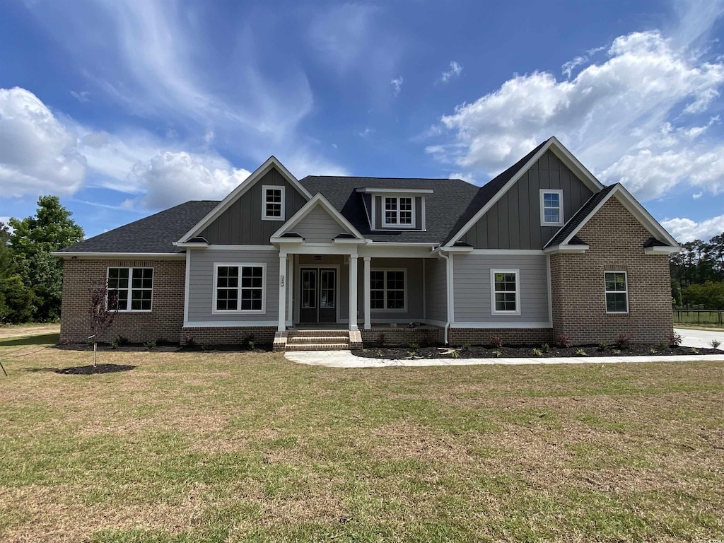 140 Pottery Landing Dr, Conway, SC 29527 - craftsman-style house with board and batten siding, a front yard, brick siding, and a shingled roof