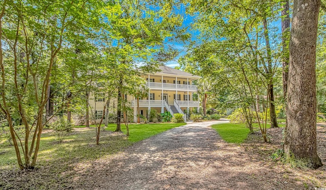 1176 Old Plantation Dr, Pawleys Island, SC 29585 - view of front of property with a porch, stairway, dirt driveway, and a front lawn