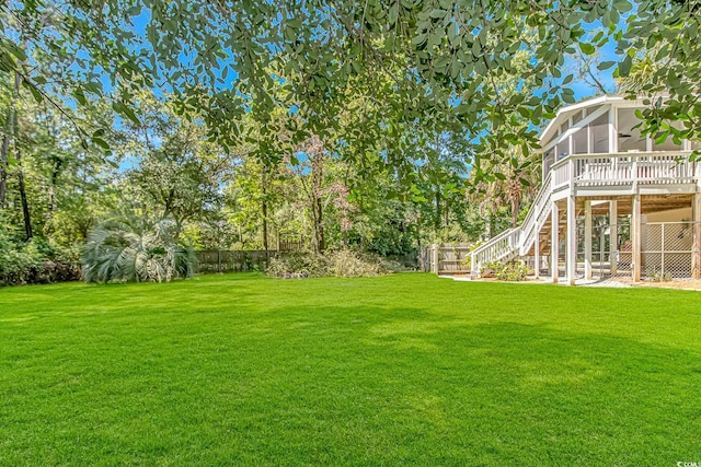 1176 Old Plantation Dr, Pawleys Island, SC 29585 - fenced backyard featuring a sunroom, stairs, and a patio area
