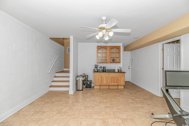 1176 Old Plantation Dr, Pawleys Island, SC 29585 - kitchen with glass insert cabinets, a ceiling fan, light stone finish flooring, brown cabinets, and dark countertops