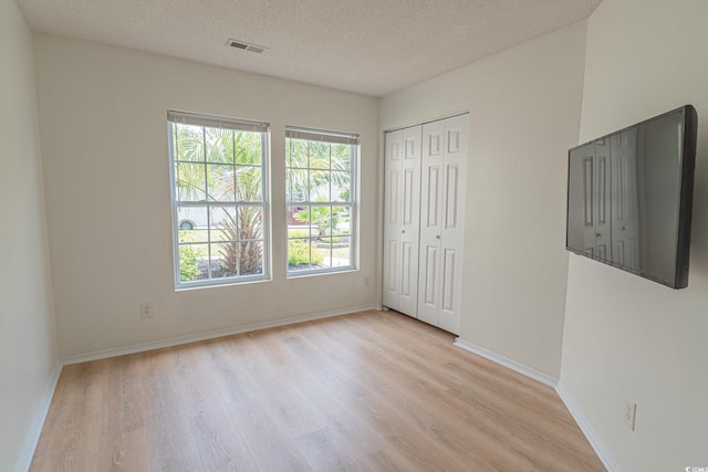 805 Cherry Bark Ct, Myrtle Beach, SC 29579 - unfurnished bedroom featuring light wood-style flooring, a textured ceiling, and a closet