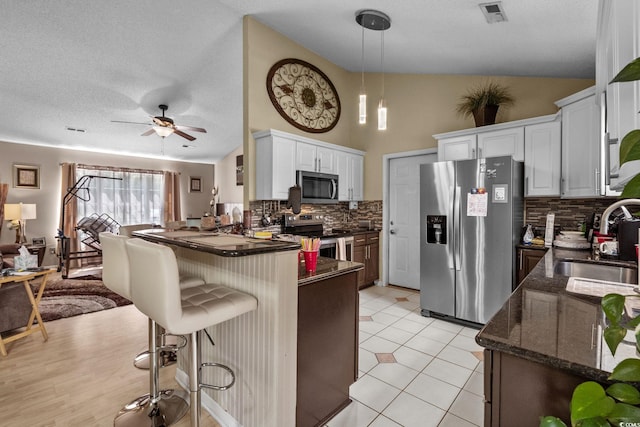 2611 Ringneck Trl, Myrtle Beach, SC 29588 - kitchen with stainless steel appliances, a peninsula, tasteful backsplash, a ceiling fan, and a textured ceiling