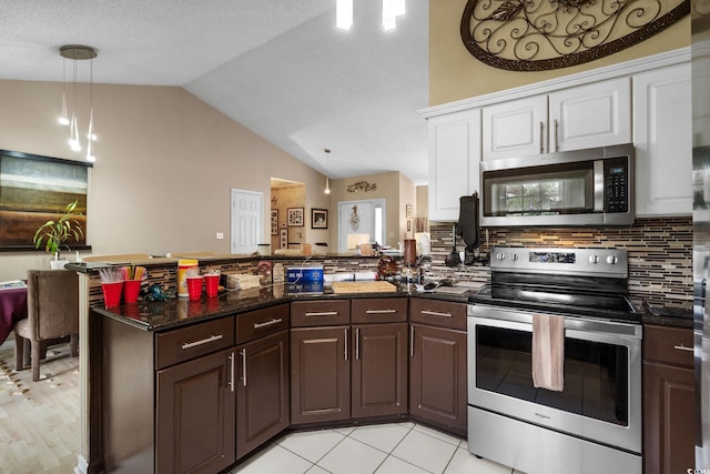 2611 Ringneck Trl, Myrtle Beach, SC 29588 - kitchen featuring appliances with stainless steel finishes, lofted ceiling, a peninsula, tasteful backsplash, and white cabinetry