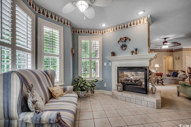 911 Tilghman Forest Dr, North Myrtle Beach, SC 29582 - living room featuring a ceiling fan, light tile patterned floors, a textured ceiling, and a glass covered fireplace