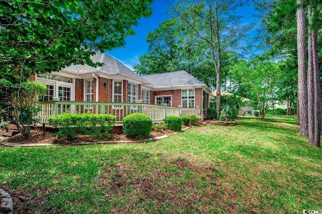 911 Tilghman Forest Dr, North Myrtle Beach, SC 29582 - view of front of property with brick siding, a front yard, and a wooden deck