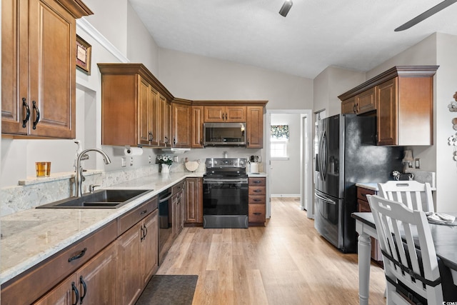 2783 Sanctuary Blvd, Conway, SC 29526 - kitchen with stainless steel appliances, vaulted ceiling, light wood finished floors, light stone countertops, and a ceiling fan