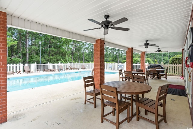 2783 Sanctuary Blvd, Conway, SC 29526 - fenced backyard with ceiling fan, a community pool, a patio area, outdoor dining space, and view of wooded area
