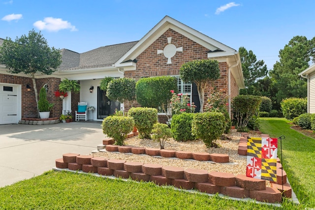 5904 Bridlewood Rd, North Myrtle Beach, SC 29582 - view of front facade with an attached garage, brick siding, concrete driveway, a front yard, and a shingled roof