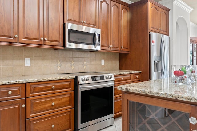 5904 Bridlewood Rd, North Myrtle Beach, SC 29582 - kitchen featuring appliances with stainless steel finishes, arched walkways, light stone countertops, and brown cabinets
