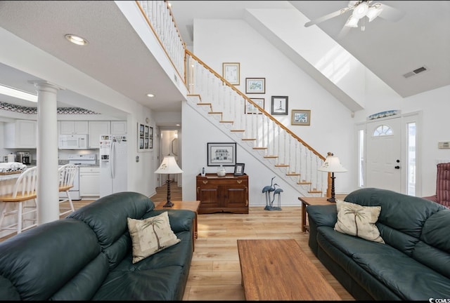 30462NDAVE N 62nd Ave N, North Myrtle Beach, SC 29582 - living area featuring high vaulted ceiling, stairs, light wood-style floors, ceiling fan, and ornate columns