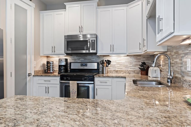 6624 Lagoon Pl, Myrtle Beach, SC 29572 - kitchen with stainless steel appliances, white cabinetry, backsplash, and light stone counters
