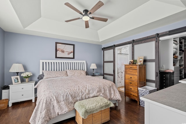 2395 Morlynn Dr, Myrtle Beach, SC 29577 - bedroom with a tray ceiling, a barn door, dark wood finished floors, and ceiling fan