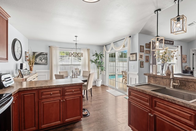 2395 Morlynn Dr, Myrtle Beach, SC 29577 - kitchen with reddish brown cabinets, dark wood-type flooring, stainless steel range with electric stovetop, decorative light fixtures, and wainscoting