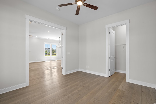 8148 Living Tide Dr, Myrtle Beach, SC 29572 - unfurnished bedroom with a chandelier, wood finished floors, a ceiling fan, a walk in closet, and recessed lighting