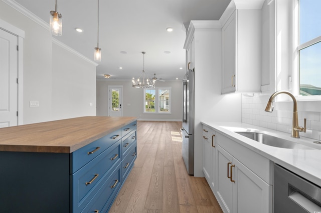 8148 Living Tide Dr, Myrtle Beach, SC 29572 - kitchen with wood counters, stainless steel appliances, blue cabinetry, a chandelier, and tasteful backsplash
