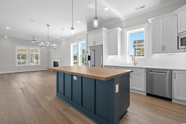 8148 Living Tide Dr, Myrtle Beach, SC 29572 - kitchen featuring stainless steel appliances, butcher block counters, backsplash, ornamental molding, and white cabinets