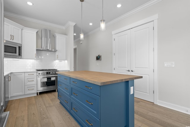 8148 Living Tide Dr, Myrtle Beach, SC 29572 - kitchen with appliances with stainless steel finishes, wooden counters, blue cabinets, wall chimney exhaust hood, and white cabinetry