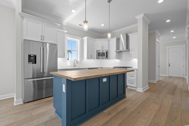 8148 Living Tide Dr, Myrtle Beach, SC 29572 - kitchen featuring stainless steel appliances, wooden counters, wall chimney range hood, white cabinets, and backsplash