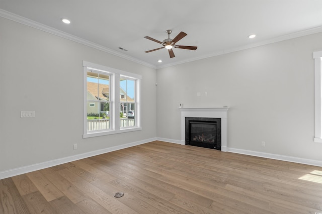 8148 Living Tide Dr, Myrtle Beach, SC 29572 - unfurnished living room featuring a ceiling fan, recessed lighting, light wood-type flooring, a glass covered fireplace, and crown molding