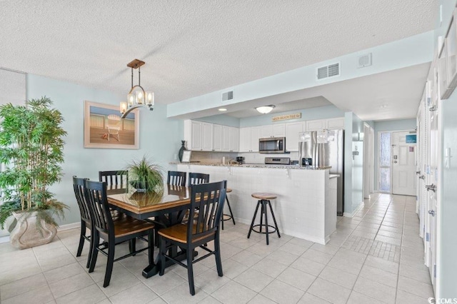 5404 N Ocean Blvd Unit 11-D, North Myrtle Beach, SC 29582 - dining area featuring a chandelier, light tile patterned flooring, and a textured ceiling