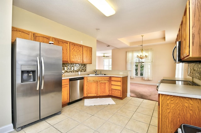 501 Painted Duck Ct, Myrtle Beach, SC 29588 - kitchen featuring stainless steel appliances, a peninsula, light countertops, tasteful backsplash, and brown cabinetry
