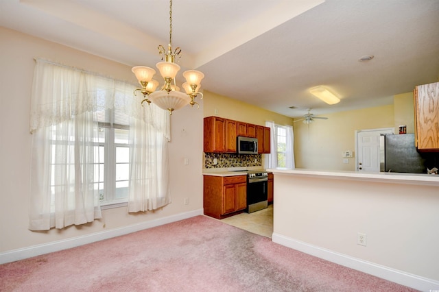 501 Painted Duck Ct, Myrtle Beach, SC 29588 - kitchen featuring appliances with stainless steel finishes, a chandelier, brown cabinetry, light colored carpet, and light countertops