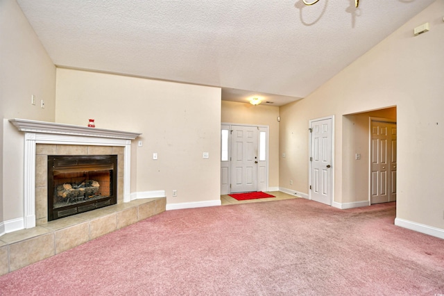 501 Painted Duck Ct, Myrtle Beach, SC 29588 - unfurnished living room featuring carpet, a tile fireplace, lofted ceiling, and a textured ceiling