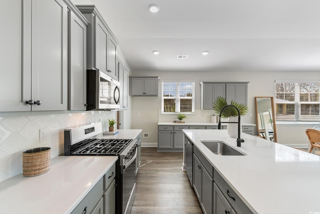 197 Bantry Ln, Conway, SC 29526 - kitchen with appliances with stainless steel finishes, gray cabinetry, dark wood-style floors, light countertops, and backsplash
