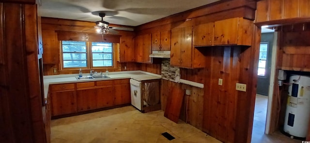 1206 French Rd, Mullins, SC 29574 - kitchen featuring under cabinet range hood, brown cabinetry, ceiling fan, wooden walls, and water heater